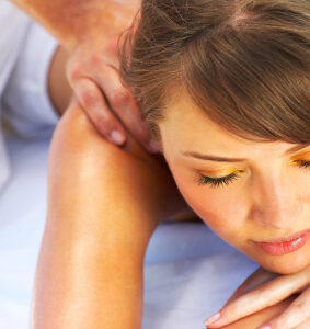 Entspannte junge Frau bei klassischer Rückenmassage mit Aromaölen in der Praxis für Physiotherapie Maria Fürstenau